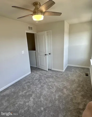 en empty room with windows and ceiling fan
