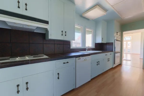 a kitchen with granite countertop a stove and wooden floor
