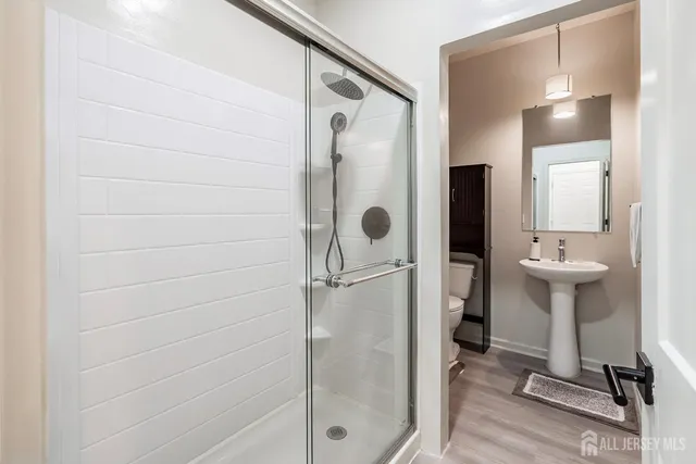 a bathroom with a sink shower and mirror