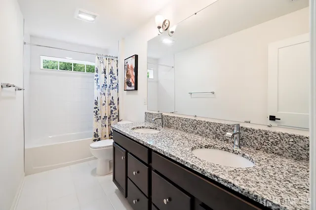 a bathroom with a granite countertop sink a toilet and bathtub