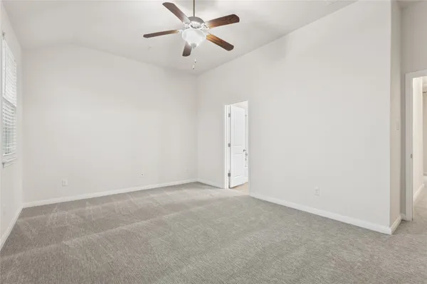 an empty room with a chandelier fan and closet