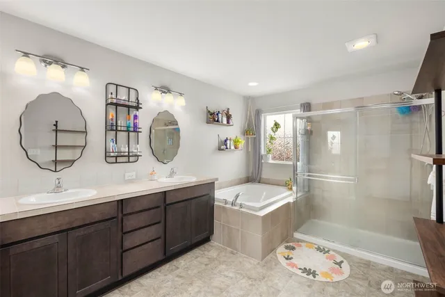 a bathroom with a double vanity sink mirror and bathtub