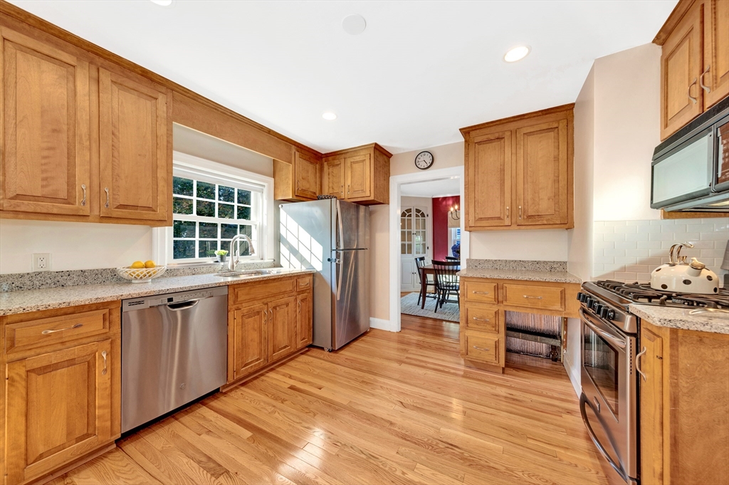 319 Appleton Street Arlington, MA 02476 - Photo 12 of 39 a kitchen with stainless steel appliances granite countertop a stove a sink dishwasher and a refrigerator with wooden cabinets