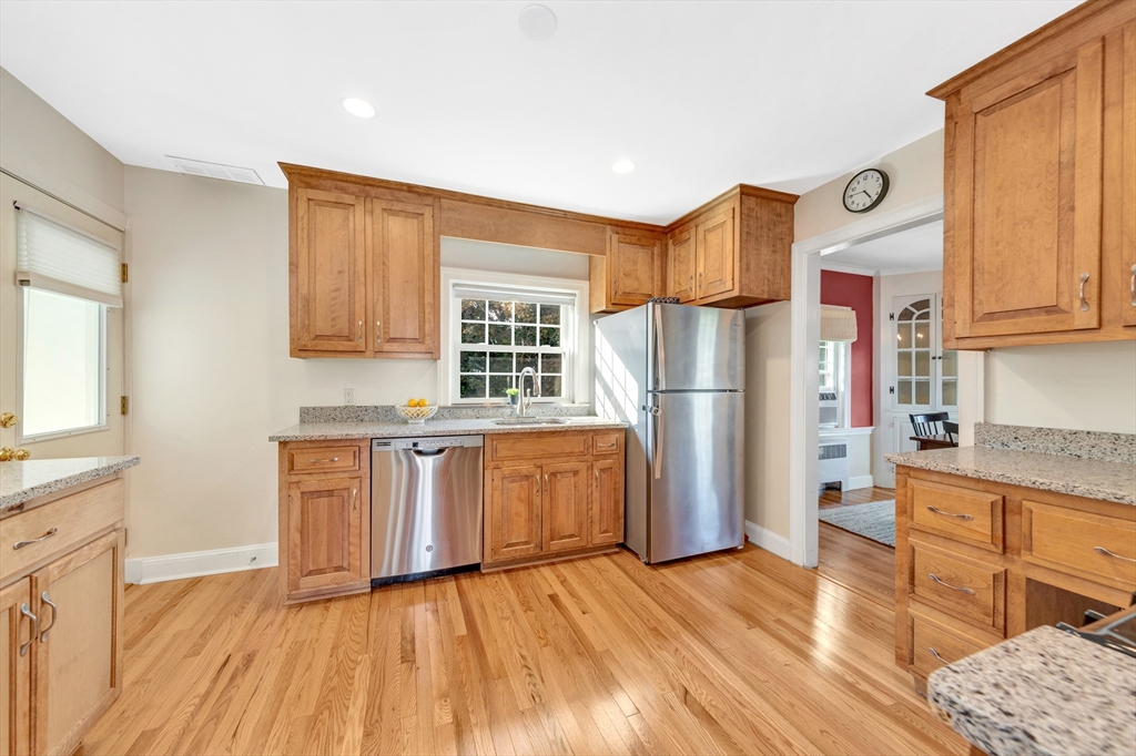 319 Appleton Street Arlington, MA 02476 - Photo 13 of 39 a kitchen with granite countertop a refrigerator oven a sink dishwasher and wooden cabinets with wooden floor