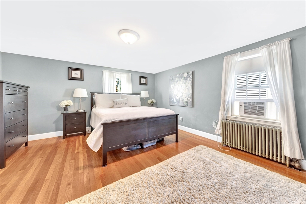 319 Appleton Street Arlington, MA 02476 - Photo 18 of 39 a bedroom with a bed and wooden floor