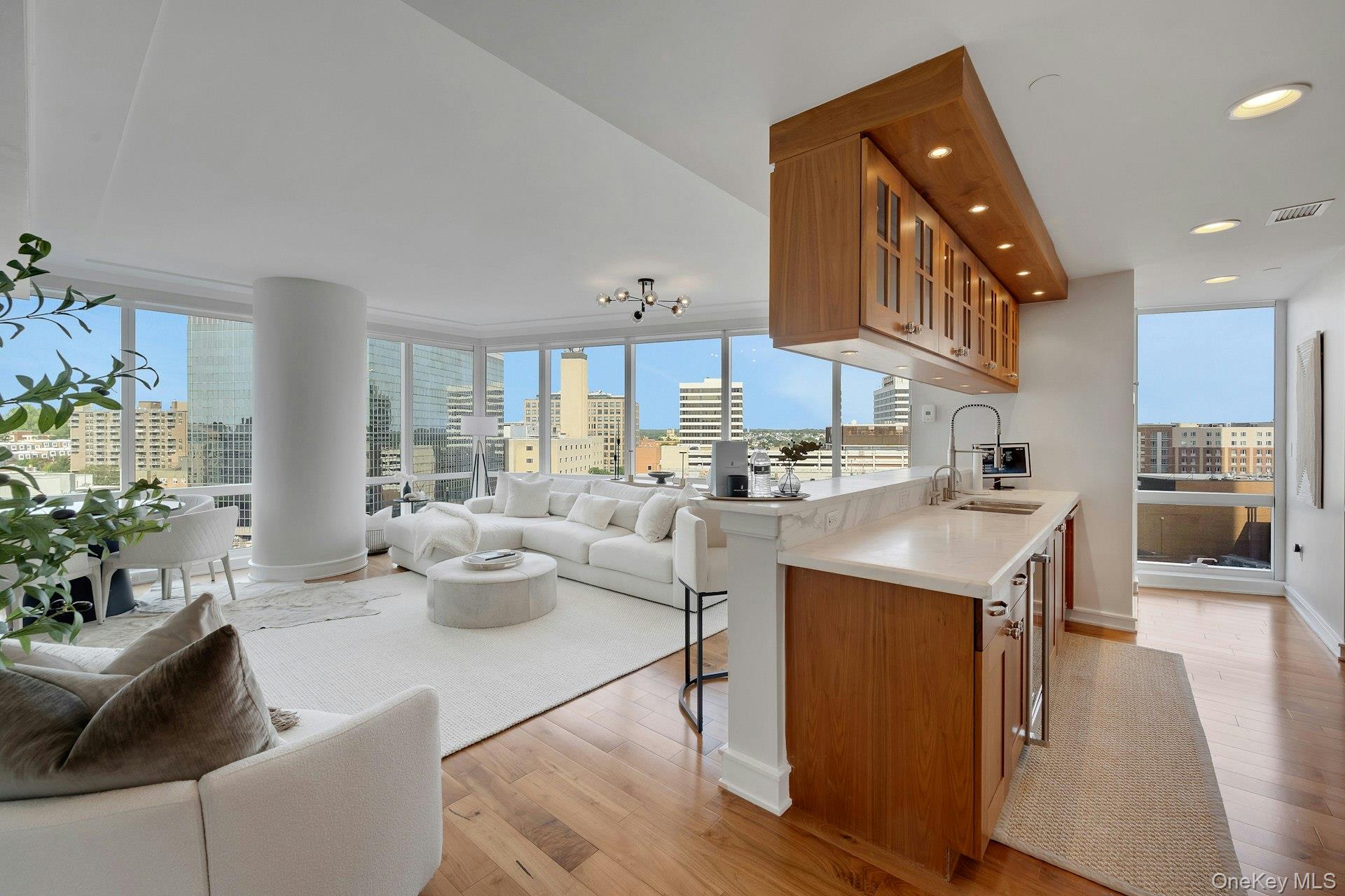 5 Renaissance Square, Unit 12A White Plains, NY 10601 - Photo 11 of 36 a kitchen with stainless steel appliances kitchen island granite countertop a sink a stove and a wooden floors