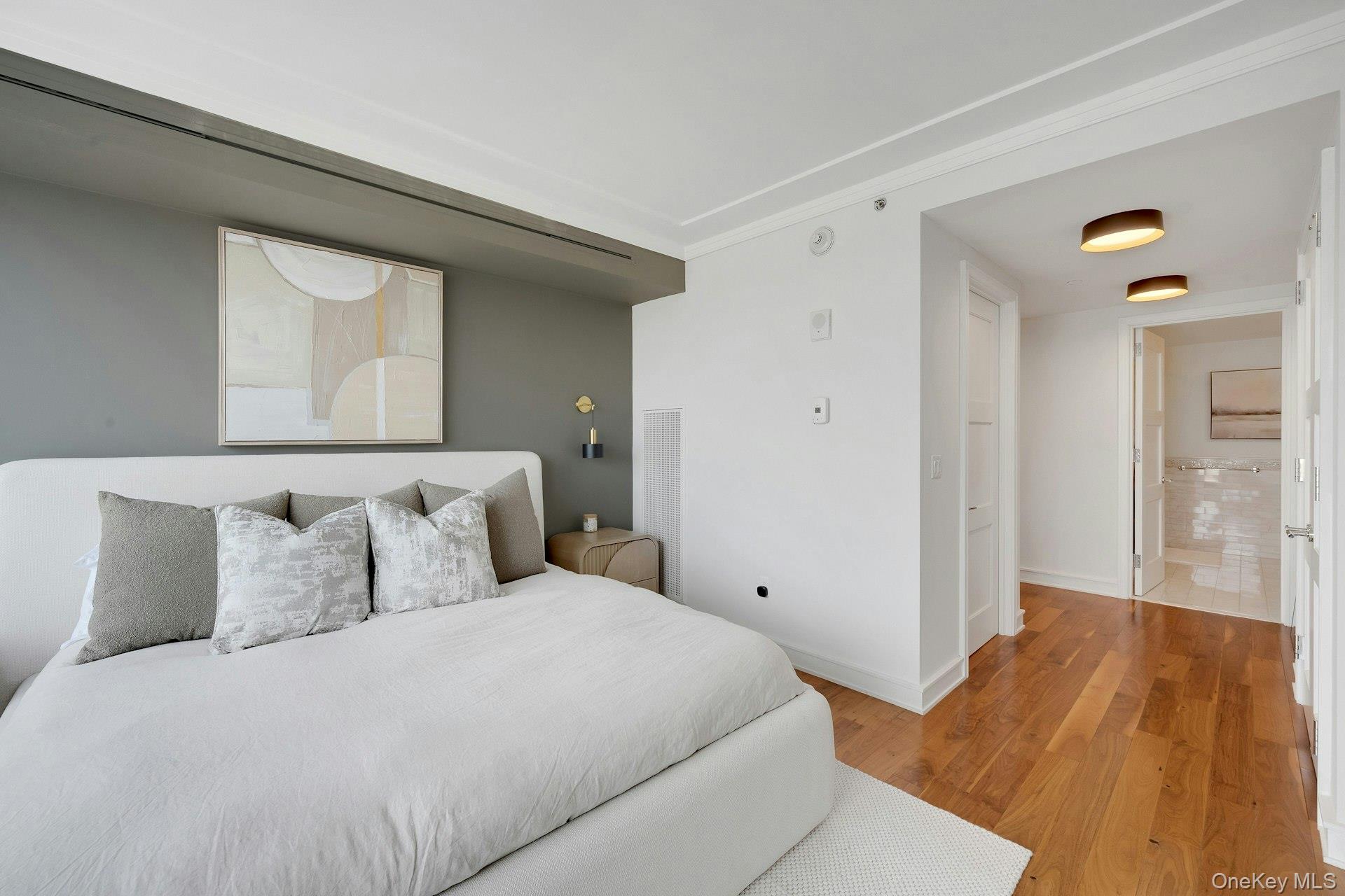 5 Renaissance Square, Unit 12A White Plains, NY 10601 - Photo 17 of 36 a bedroom with a bed and wooden floor