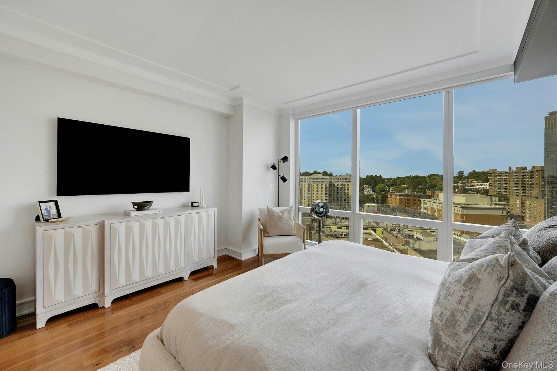 5 Renaissance Square, Unit 12A White Plains, NY 10601 - Photo 18 of 36 a bedroom with furniture and a flat screen tv
