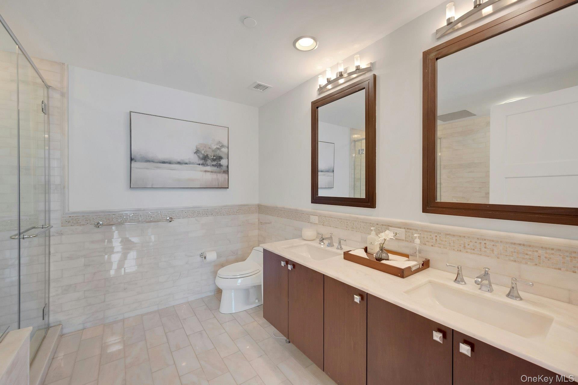 5 Renaissance Square, Unit 12A White Plains, NY 10601 - Photo 20 of 36 a bathroom with a double vanity sink toilet and mirror
