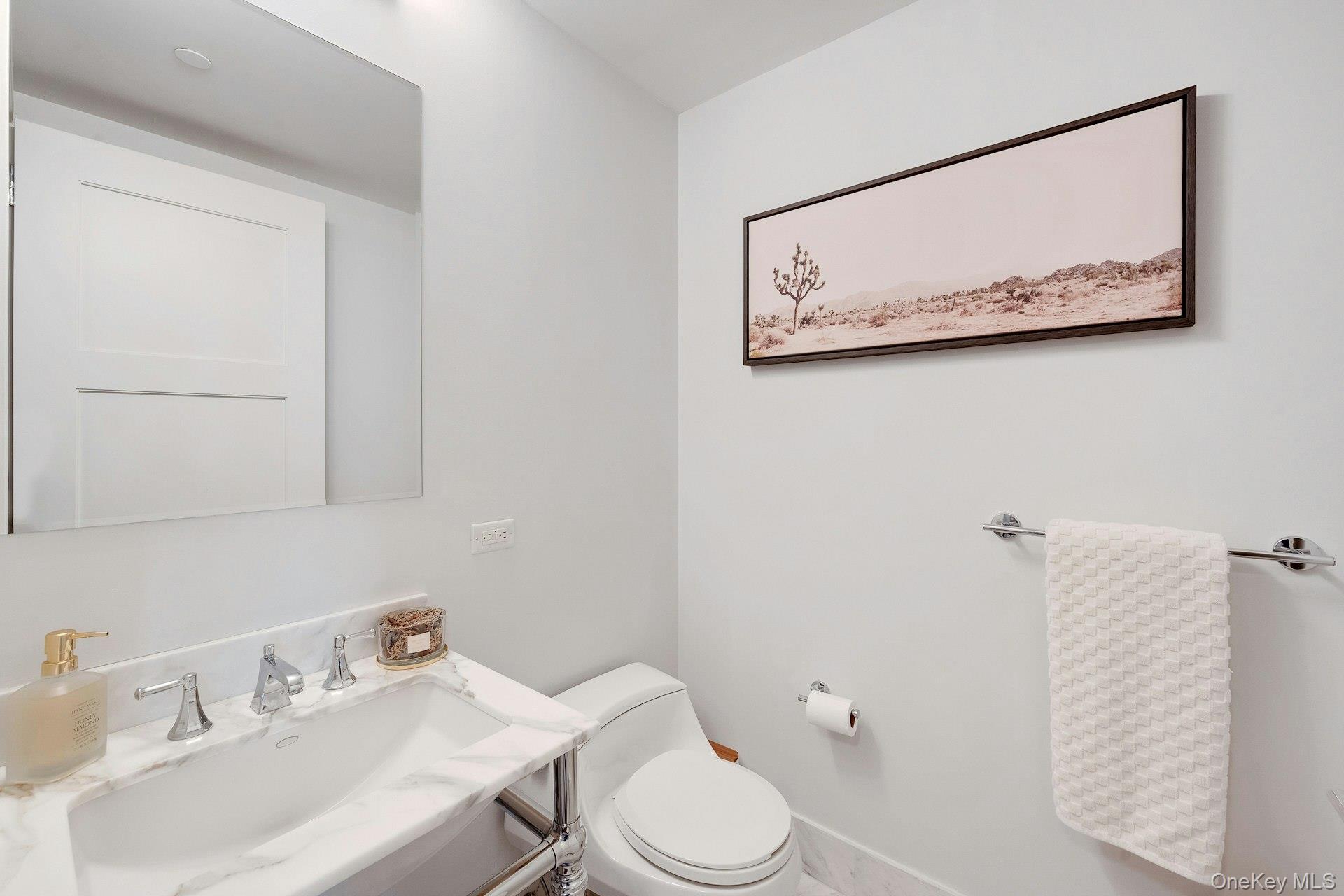 5 Renaissance Square, Unit 12A White Plains, NY 10601 - Photo 24 of 36 a bathroom with a toilet sink and mirror
