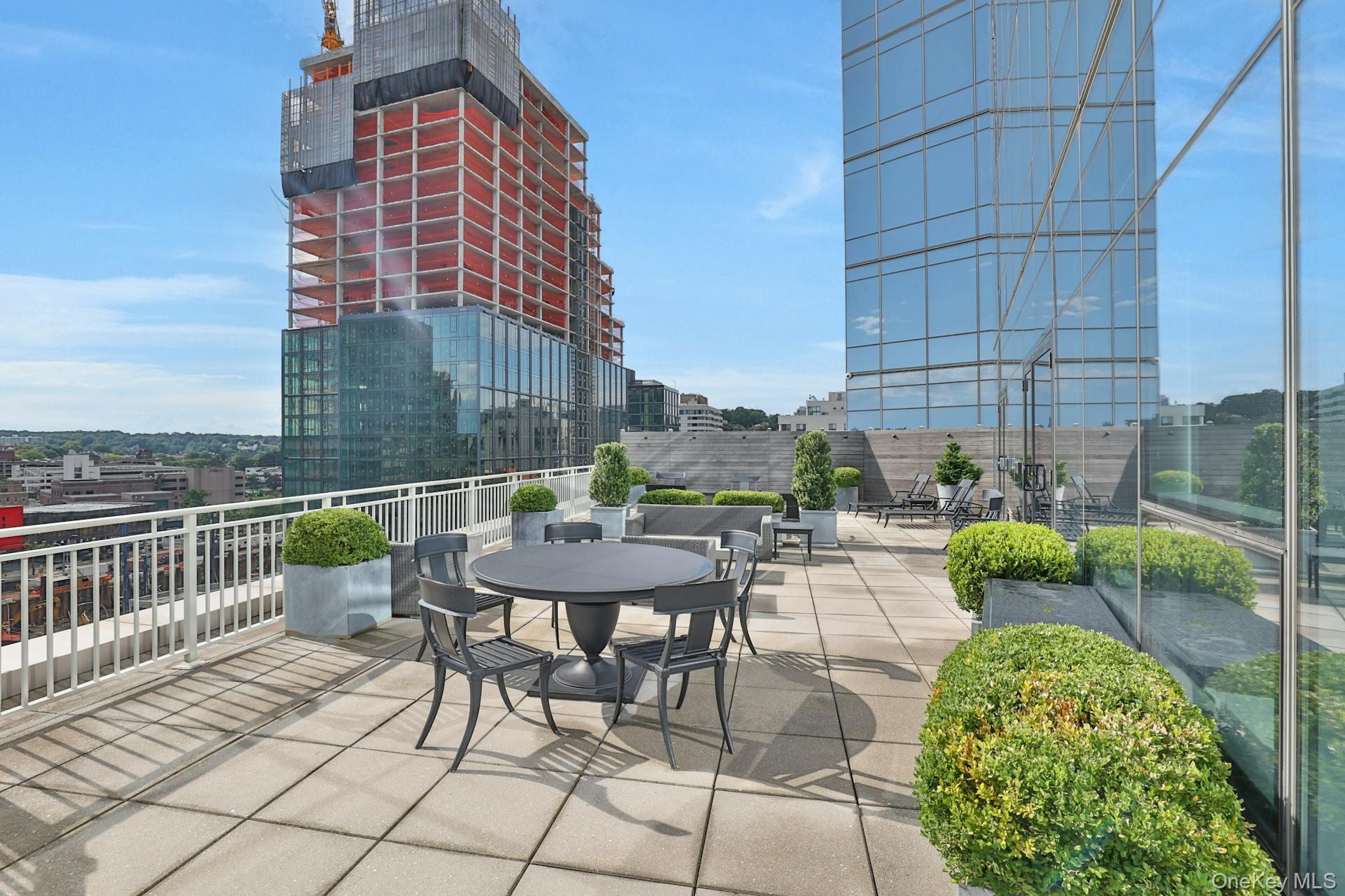 5 Renaissance Square, Unit 12A White Plains, NY 10601 - Photo 35 of 36 a view of a chairs and table in the back yard