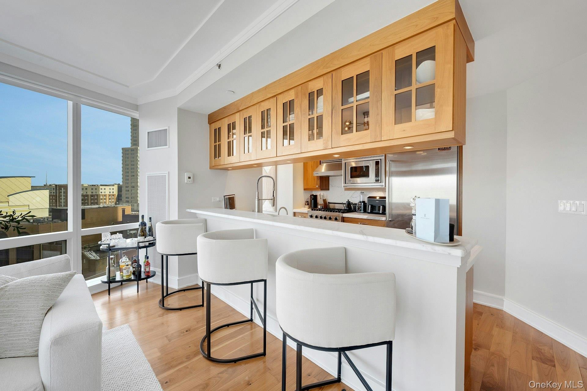 5 Renaissance Square, Unit 12A White Plains, NY 10601 - Photo 6 of 36 a kitchen with stainless steel appliances granite countertop a table chairs and a living room view