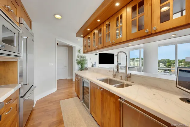 a living room with stainless steel appliances kitchen island granite countertop a table chairs and a view of kitchen