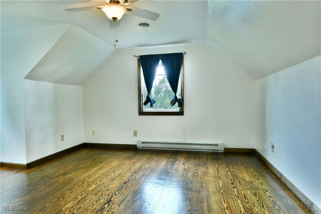 1141 Howell Road East Palestine, OH 44413 - Photo 31 of 41 Bonus room featuring dark wood-type flooring, lofted ceiling, a baseboard radiator, and a ceiling fan