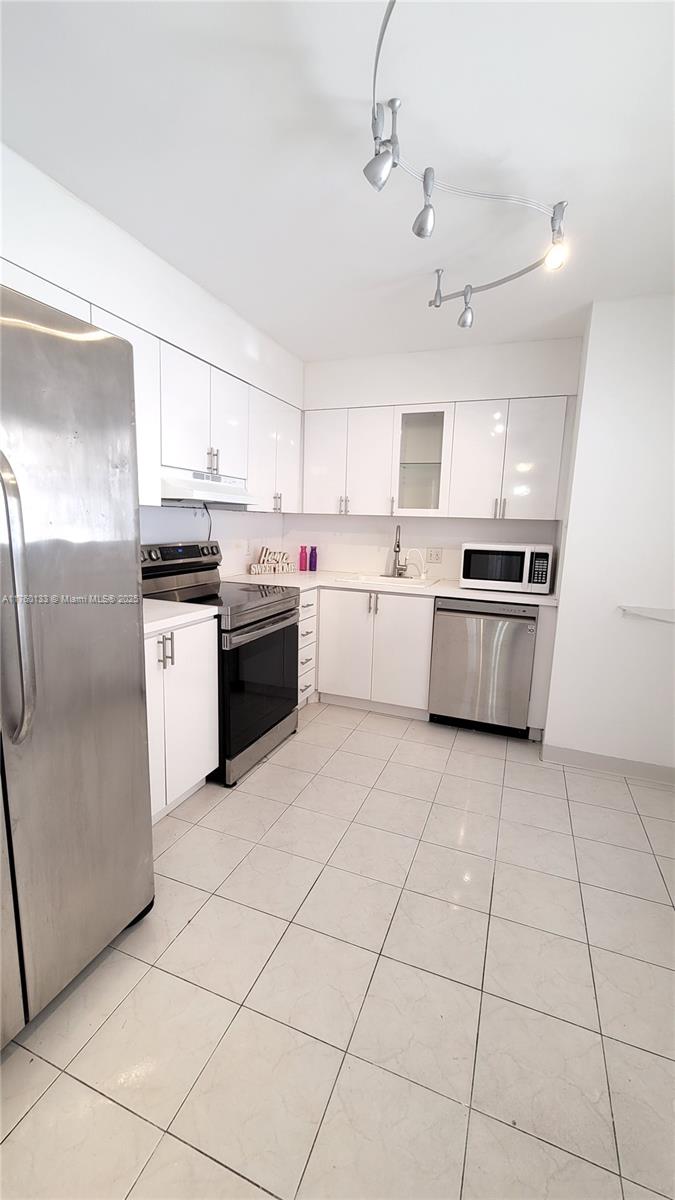2801 Northeast 183rd Street, Unit 504W Aventura, FL 33160 - Photo 11 of 36 a kitchen with stainless steel appliances granite countertop a stove top oven a sink dishwasher and a refrigerator