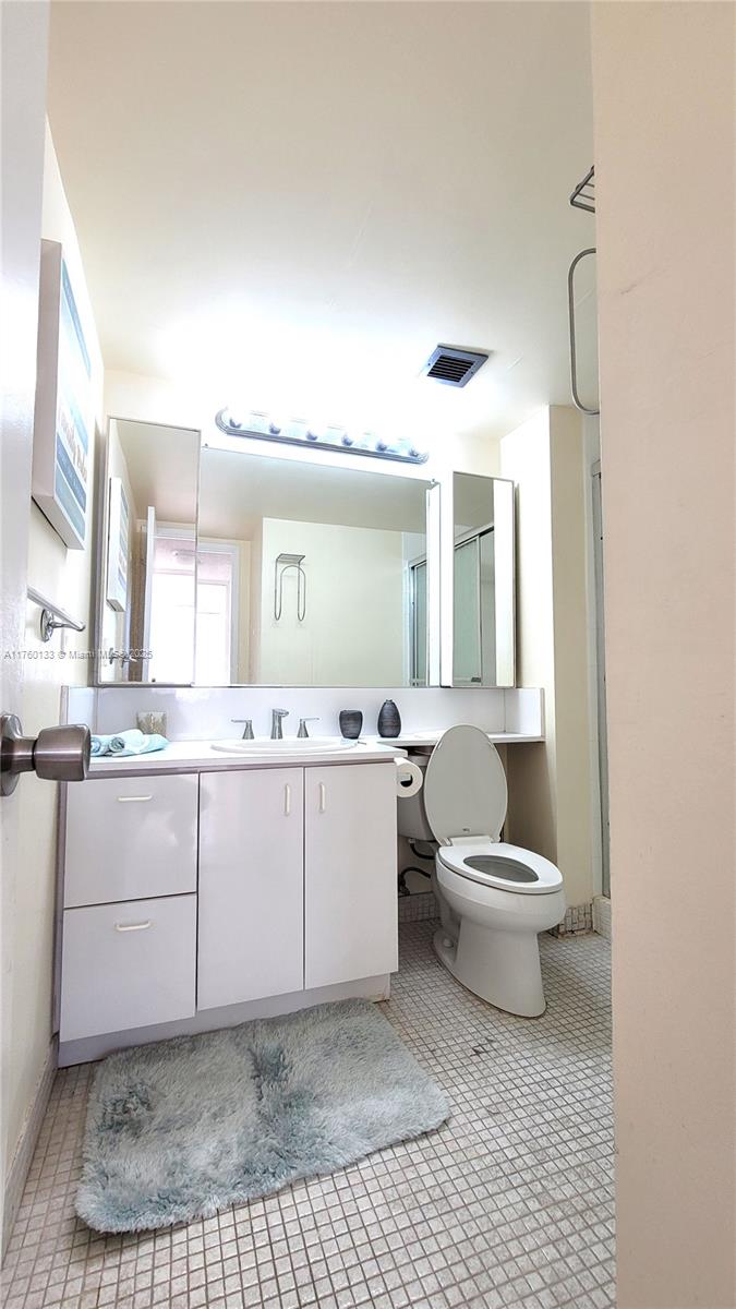 2801 Northeast 183rd Street, Unit 504W Aventura, FL 33160 - Photo 18 of 36 a bathroom with a sink a toilet and mirror