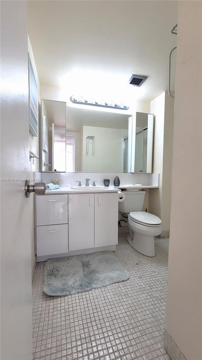 2801 Northeast 183rd Street, Unit 504W Aventura, FL 33160 - Photo 19 of 36 a bathroom with a sink a toilet and mirror