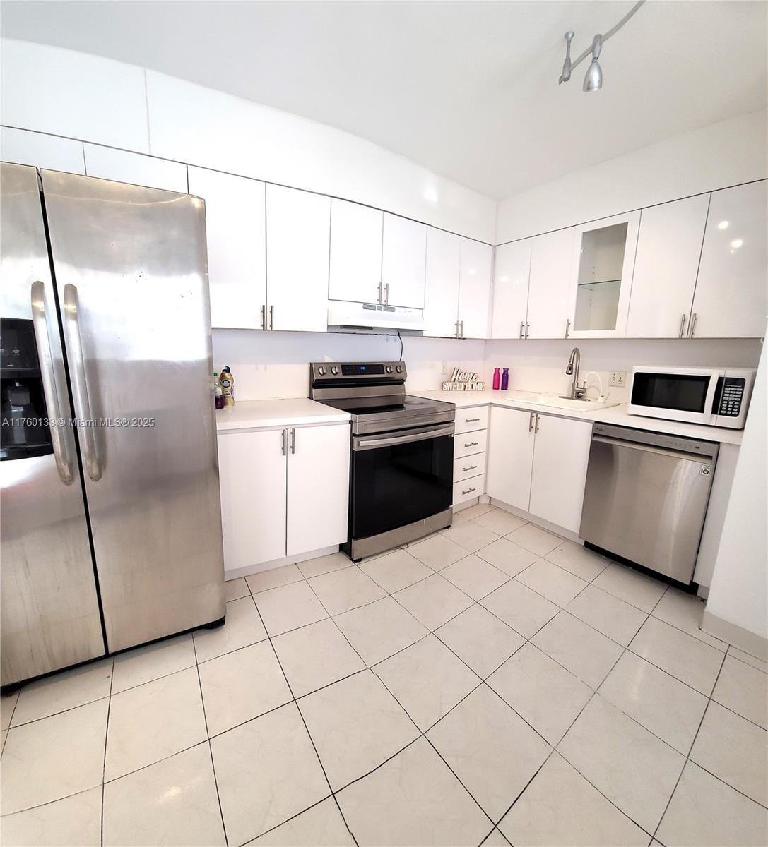 2801 Northeast 183rd Street, Unit 504W Aventura, FL 33160 - Photo 10 of 36 a kitchen with stainless steel appliances granite countertop a stove a sink and a refrigerator