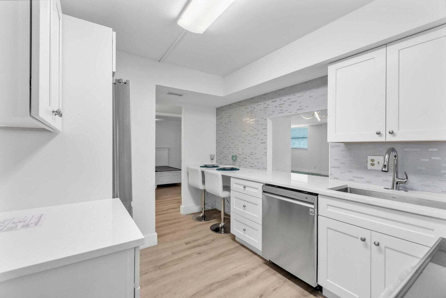 299 Northwest 52nd Terrace, Unit 118 Boca Raton, FL 33487 - Photo 1 of 28 a kitchen with a sink a stove cabinets and wooden floor