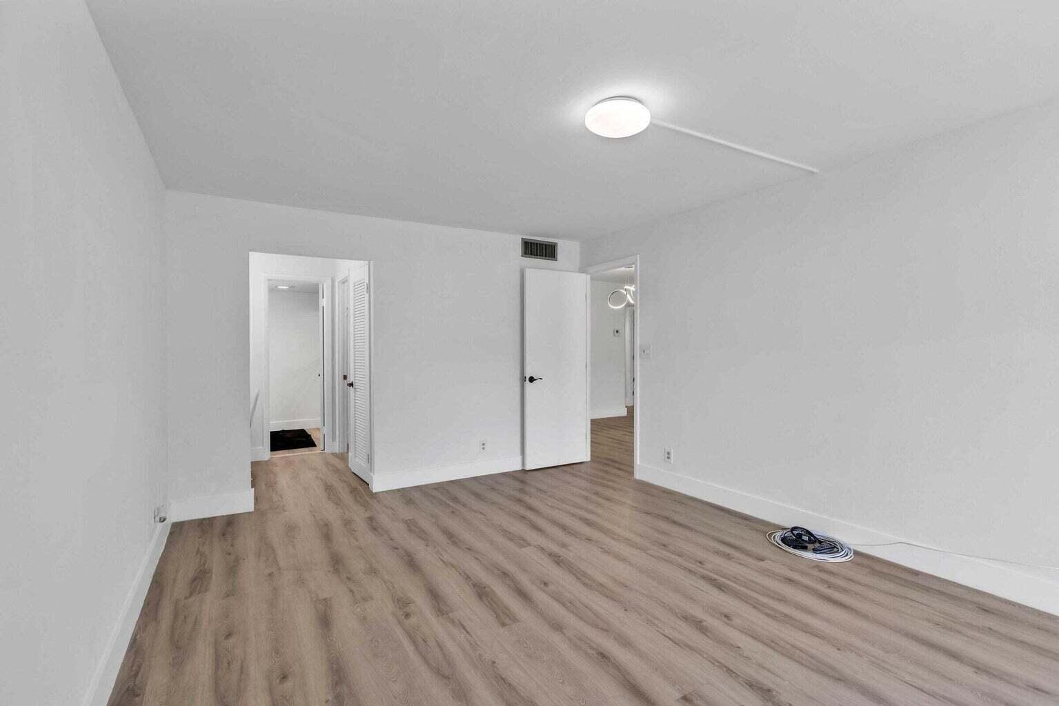 299 Northwest 52nd Terrace, Unit 118 Boca Raton, FL 33487 - Photo 12 of 28 a view of a room with wooden floor and white walls