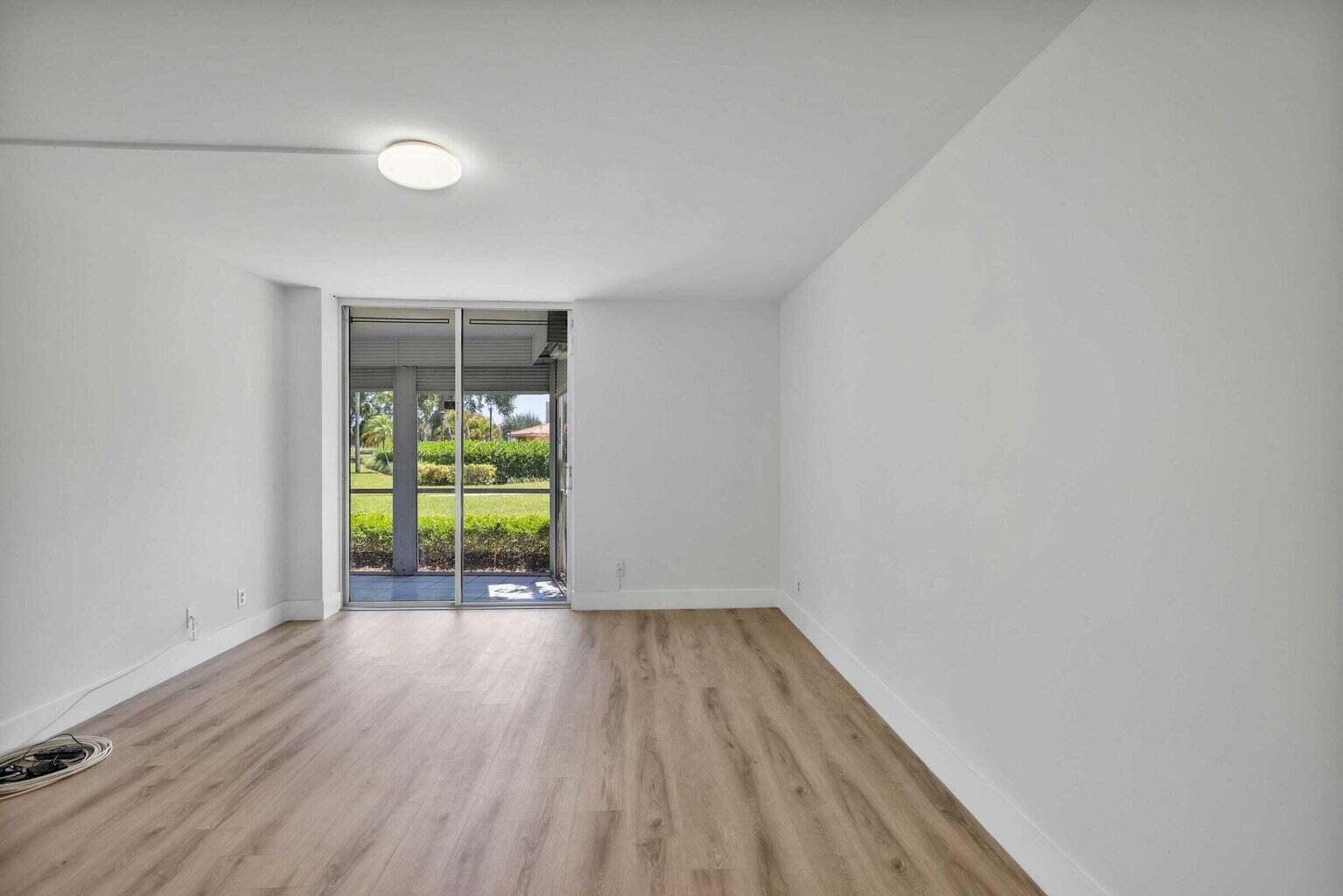 299 Northwest 52nd Terrace, Unit 118 Boca Raton, FL 33487 - Photo 13 of 28 a view of room with window and wooden floor