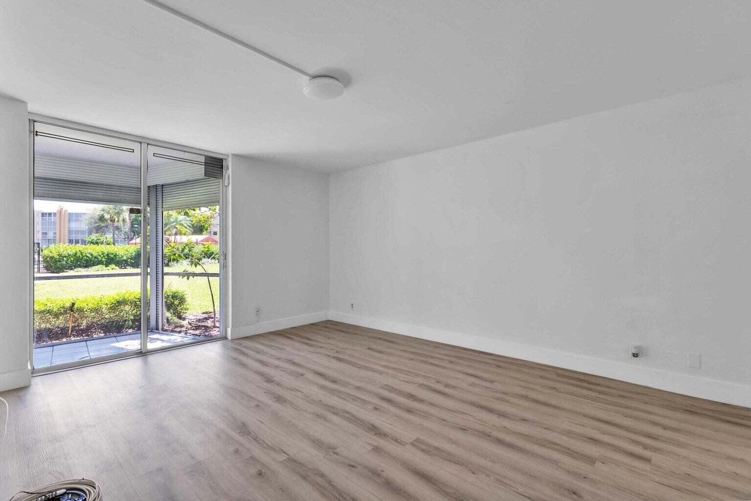 299 Northwest 52nd Terrace, Unit 118 Boca Raton, FL 33487 - Photo 14 of 28 an empty room with wooden floor and windows