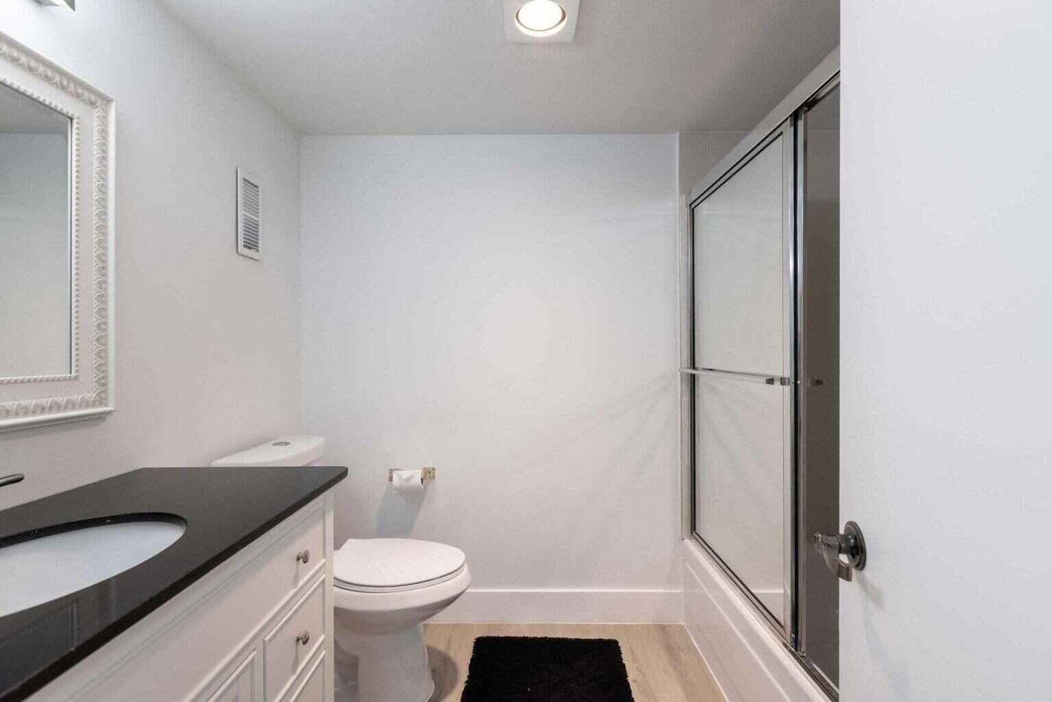 299 Northwest 52nd Terrace, Unit 118 Boca Raton, FL 33487 - Photo 17 of 28 a white toilet sitting next to a bathroom sink