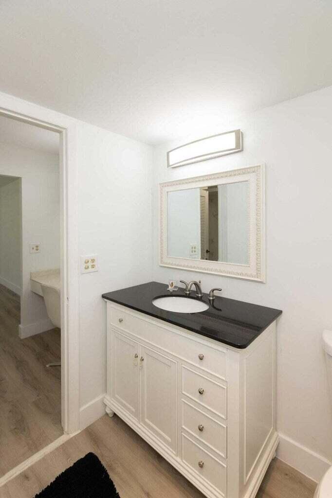 299 Northwest 52nd Terrace, Unit 118 Boca Raton, FL 33487 - Photo 19 of 28 a bathroom with a granite countertop sink and a mirror