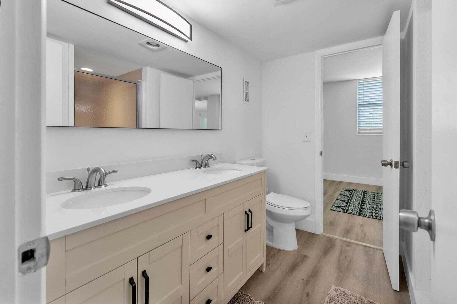 299 Northwest 52nd Terrace, Unit 118 Boca Raton, FL 33487 - Photo 23 of 28 a bathroom with a double vanity sink toilet and shower