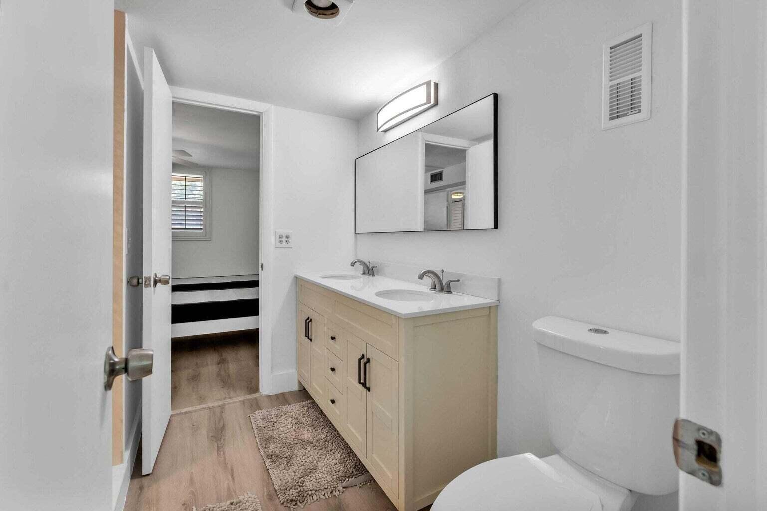 299 Northwest 52nd Terrace, Unit 118 Boca Raton, FL 33487 - Photo 24 of 28 a bathroom with a toilet sink and mirror
