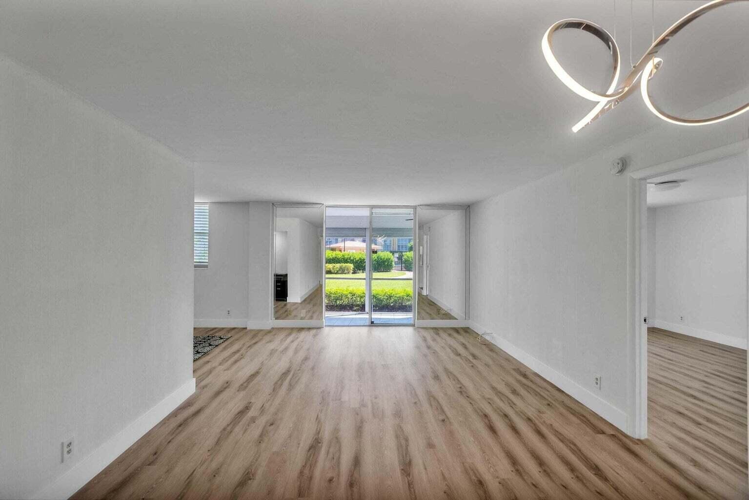 299 Northwest 52nd Terrace, Unit 118 Boca Raton, FL 33487 - Photo 4 of 28 a view of room with window and wooden floor