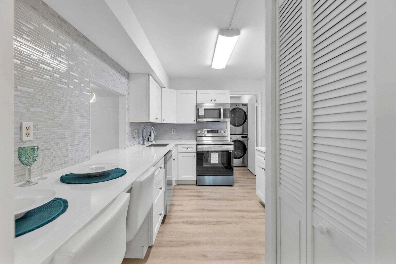 299 Northwest 52nd Terrace, Unit 118 Boca Raton, FL 33487 - Photo 7 of 28 a kitchen with stainless steel appliances granite countertop a sink a stove and cabinets