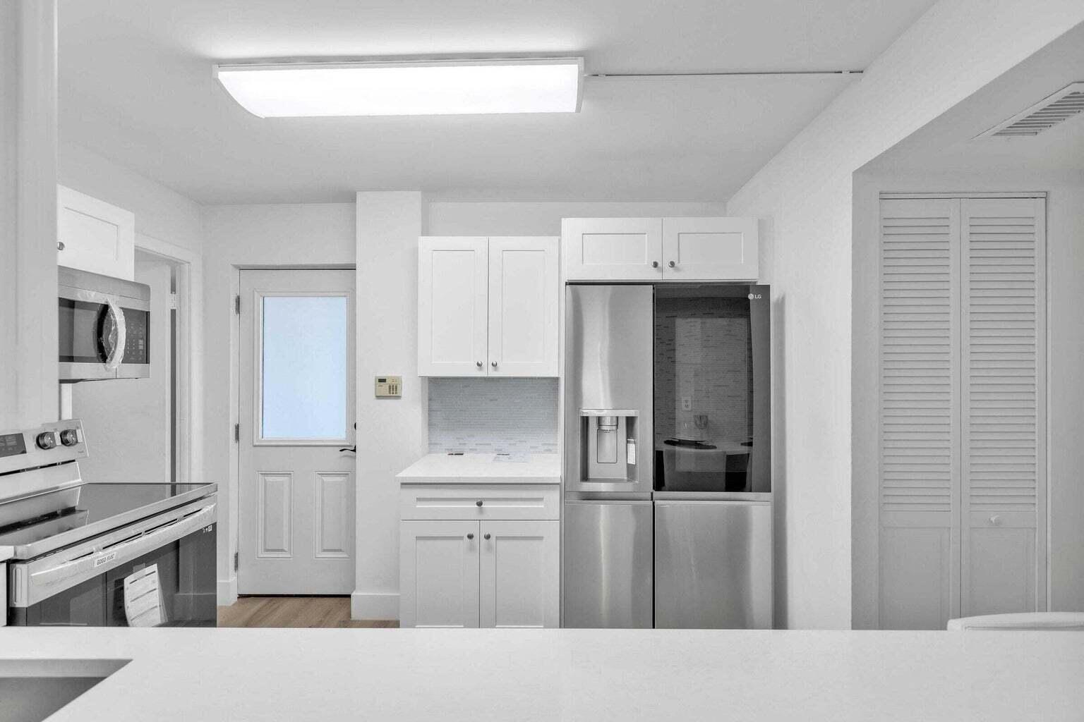 299 Northwest 52nd Terrace, Unit 118 Boca Raton, FL 33487 - Photo 8 of 28 a kitchen with a refrigerator stove and cabinets