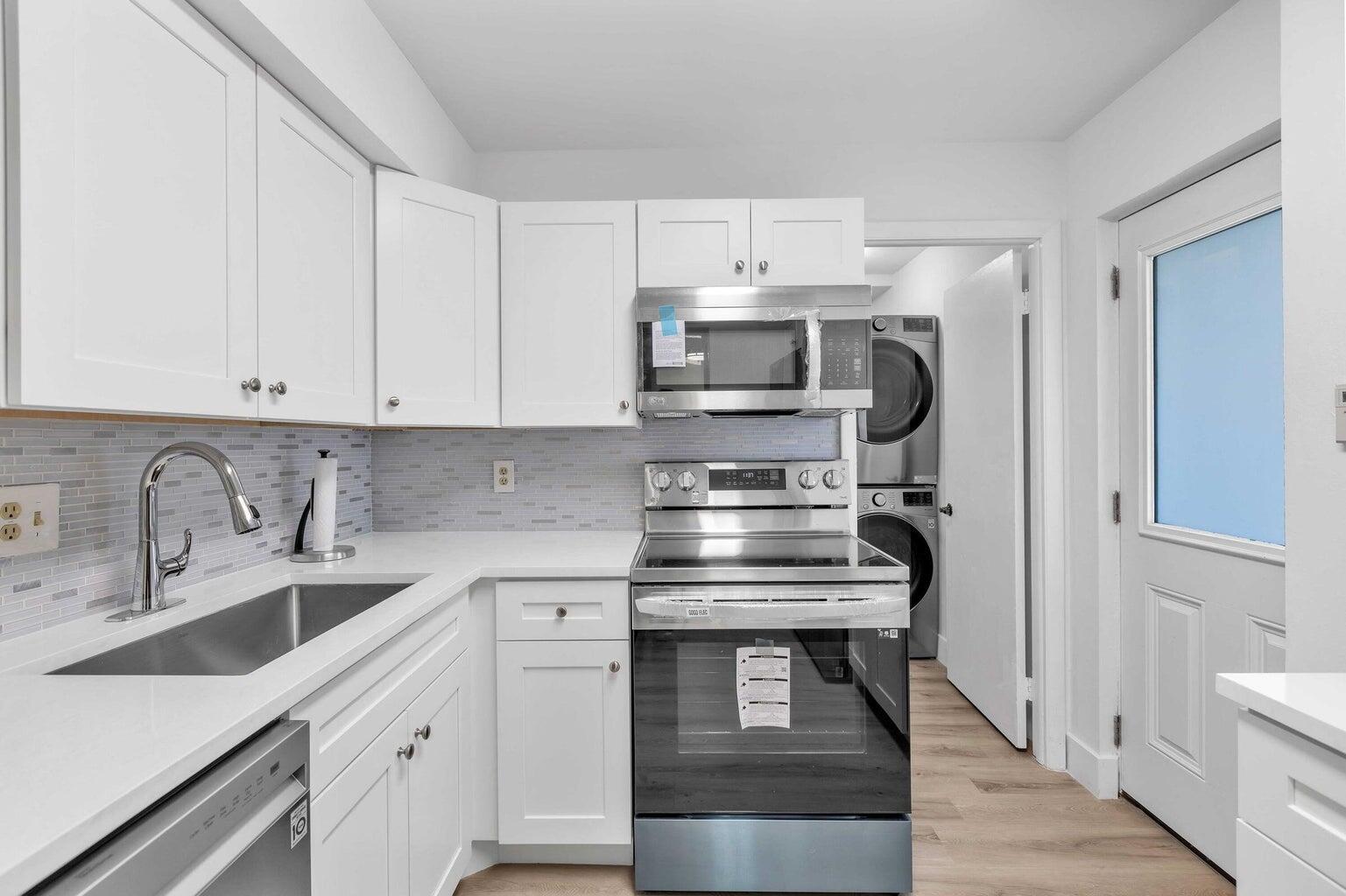 299 Northwest 52nd Terrace, Unit 118 Boca Raton, FL 33487 - Photo 9 of 28 a kitchen with stainless steel appliances a sink and cabinets