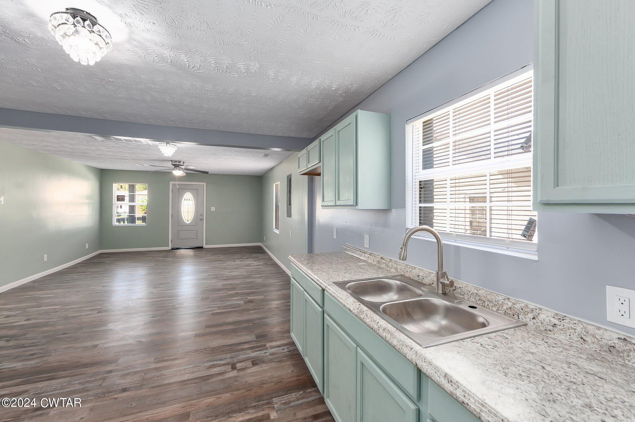 62 Everett Street Jackson, TN 38301 - Photo 10 of 28 a kitchen with granite countertop a sink a stove cabinets and wooden floor