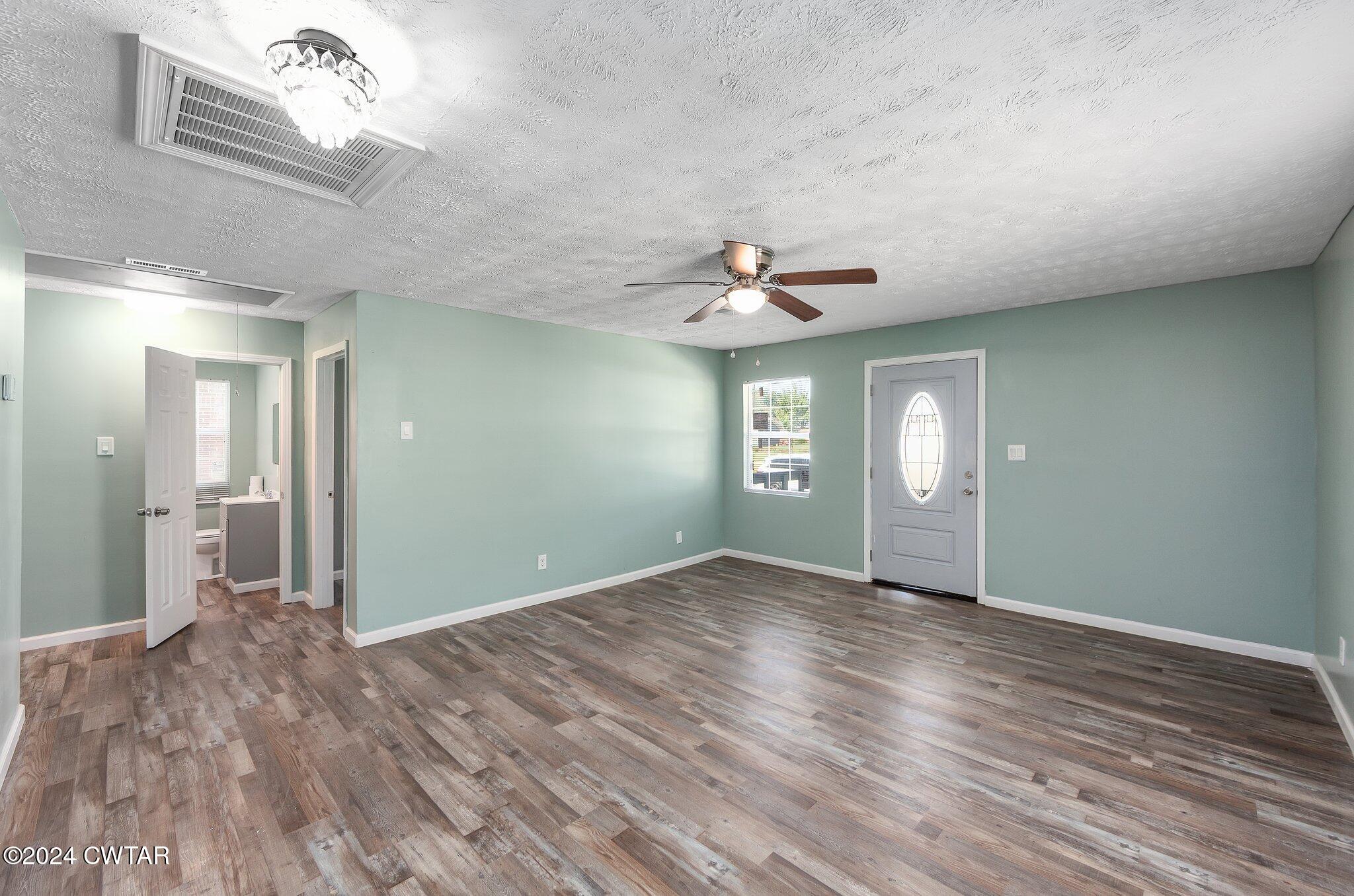 62 Everett Street Jackson, TN 38301 - Photo 6 of 28 a view of an empty room with window and wooden floor