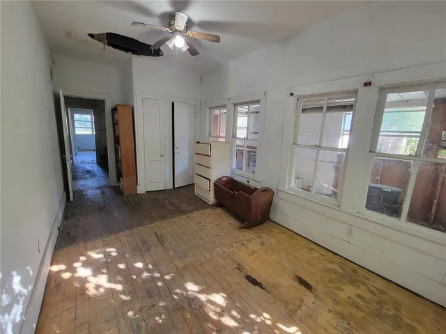 a view of a refrigerator in kitchen and an empty room