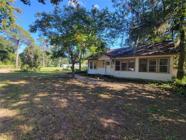 a view of a house with yard and a tree