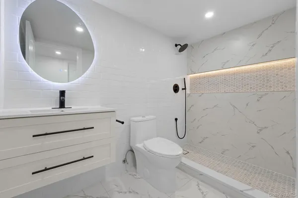 a bathroom with a toilet a sink and mirror