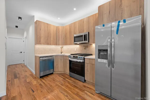 a kitchen with stainless steel appliances a refrigerator sink and microwave