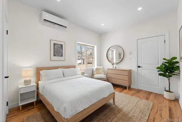 a bedroom with a bed a dresser and window