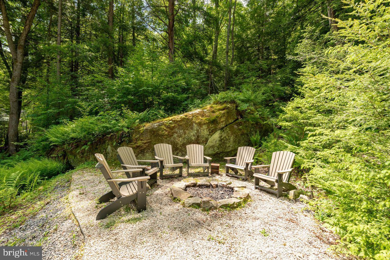 2678 Mayhew Inn Road Oakland, MD 21550 - Photo 11 of 33 Cozy fire pit nestled in lush greenery.