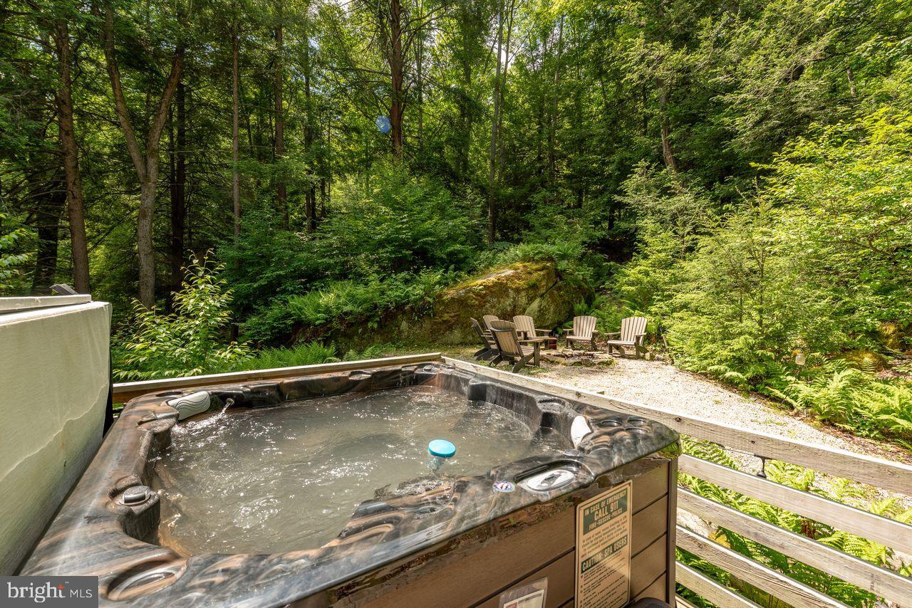 2678 Mayhew Inn Road Oakland, MD 21550 - Photo 33 of 33 Serene hot tub nestled in lush greenery.