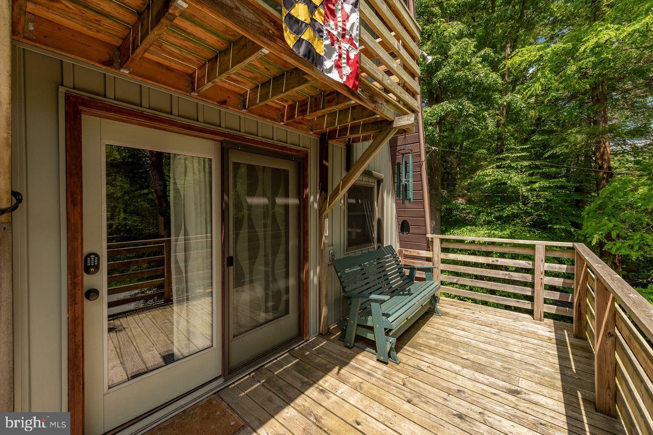 2678 Mayhew Inn Road Oakland, MD 21550 - Photo 5 of 33 Charming deck nestled in lush greenery.