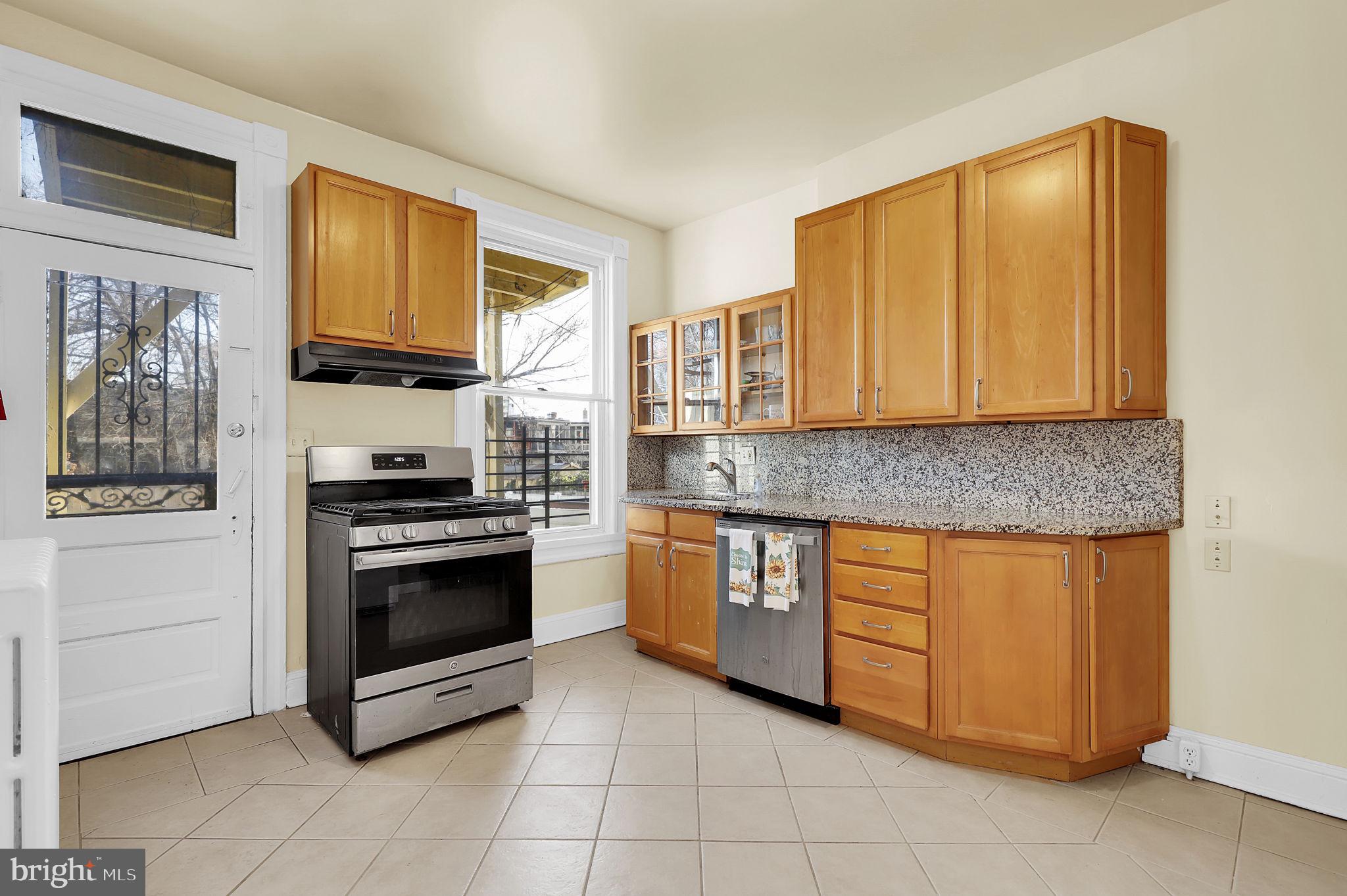 2511 North Calvert Street Baltimore, MD 21218 - Photo 11 of 37 a kitchen with stainless steel appliances granite countertop a stove a sink and a microwave