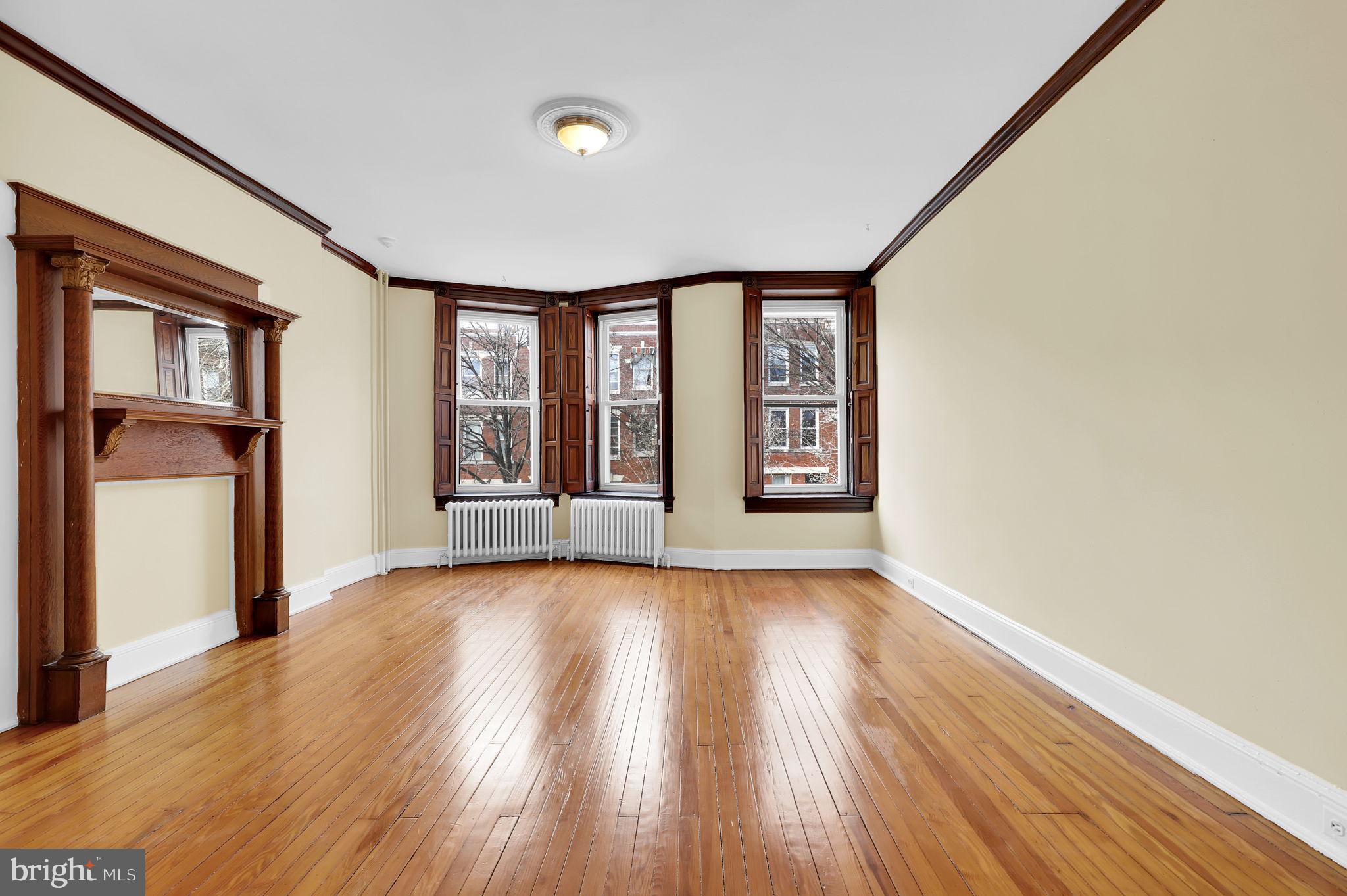 2511 North Calvert Street Baltimore, MD 21218 - Photo 19 of 37 wooden floor in an empty room with a window