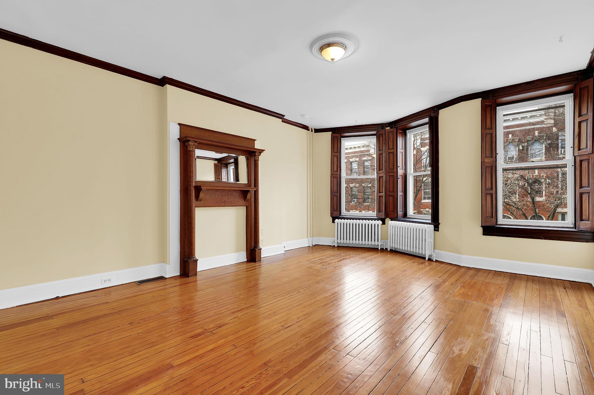 2511 North Calvert Street Baltimore, MD 21218 - Photo 20 of 37 a view of an empty room with window and wooden floor