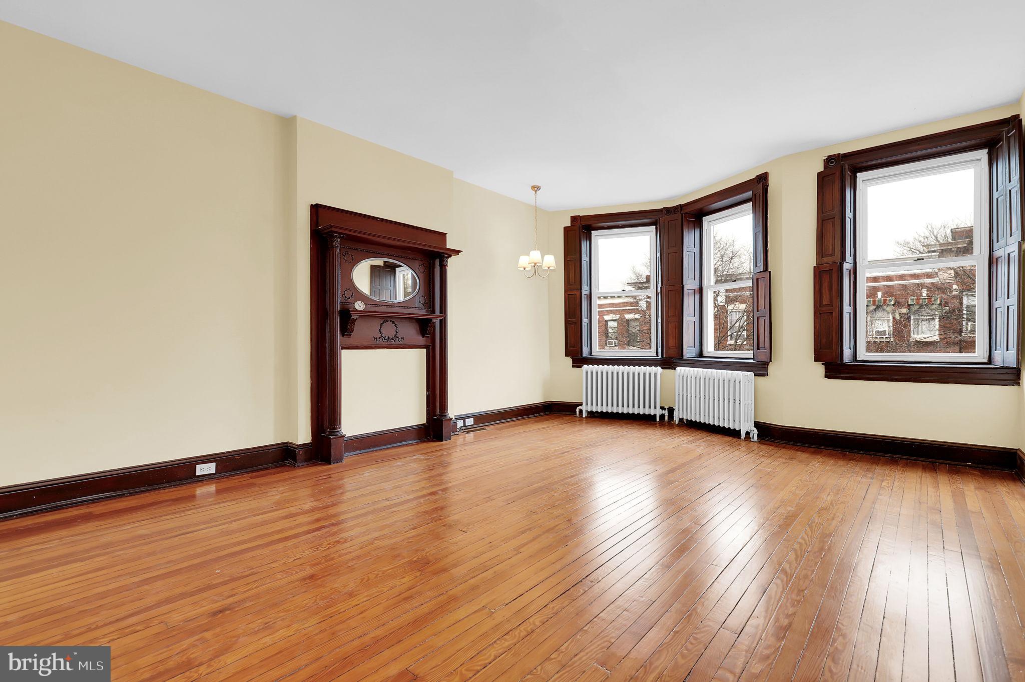 2511 North Calvert Street Baltimore, MD 21218 - Photo 27 of 37 a view of an empty room with a window and wooden floor