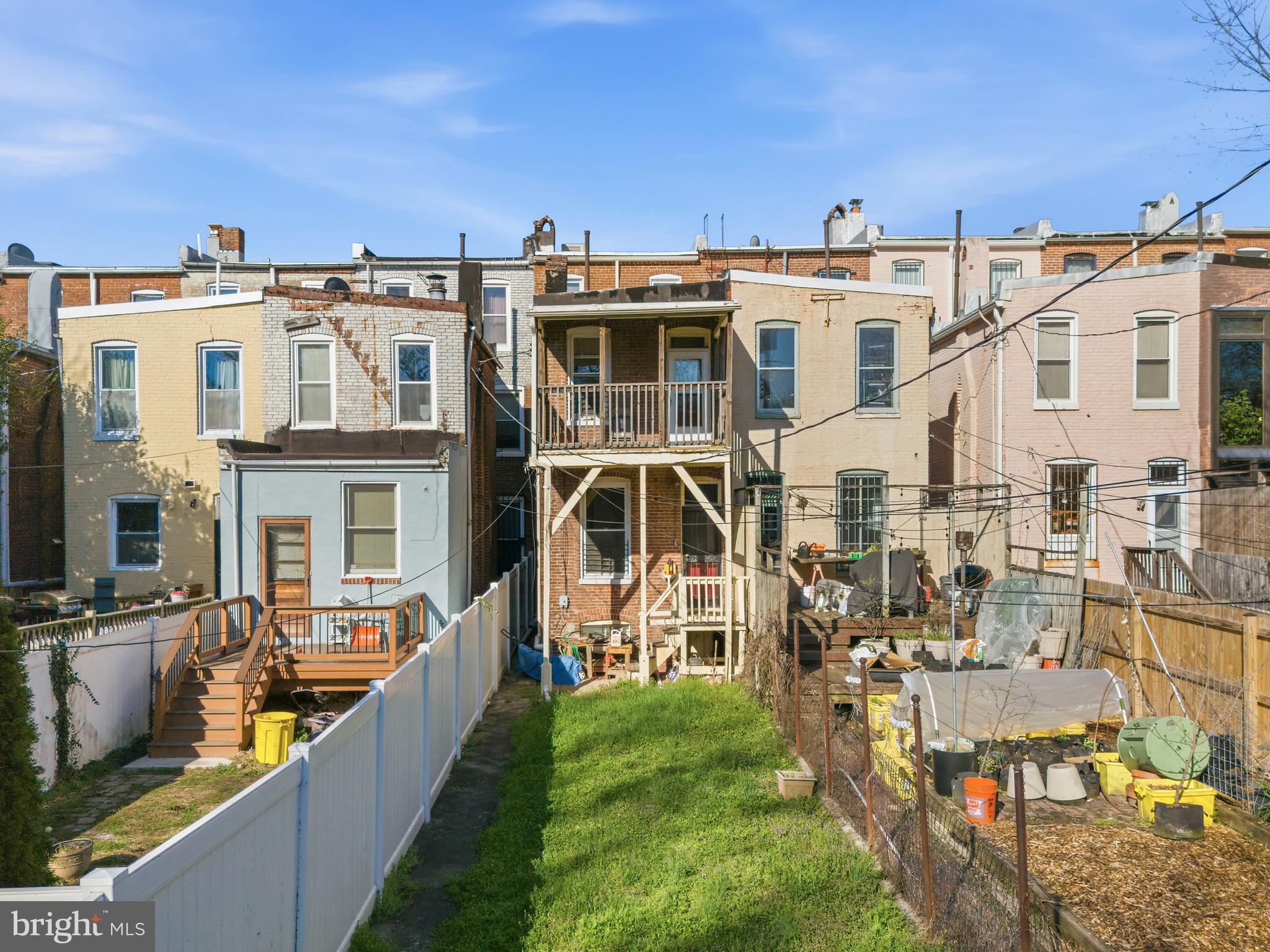 2511 North Calvert Street Baltimore, MD 21218 - Photo 34 of 37 a view of a white building with a big yard and potted plants