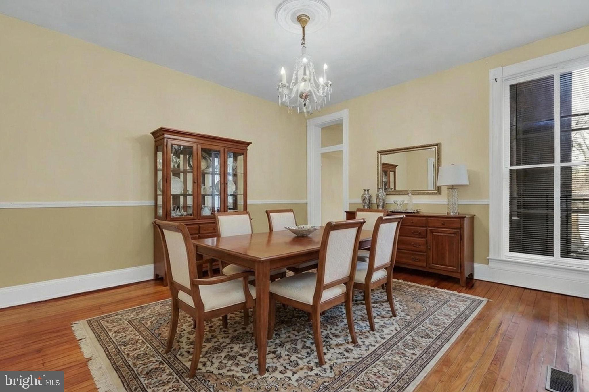2511 North Calvert Street Baltimore, MD 21218 - Photo 6 of 37 a view of a dining room with furniture a chandelier and wooden floor
